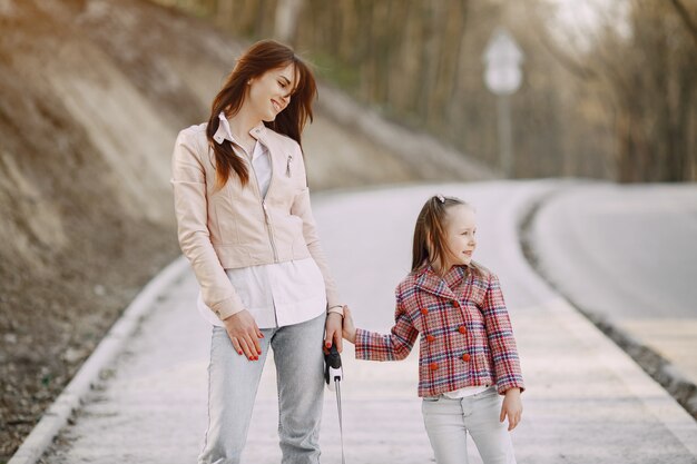 Elegant mother with daughter in a summer forest