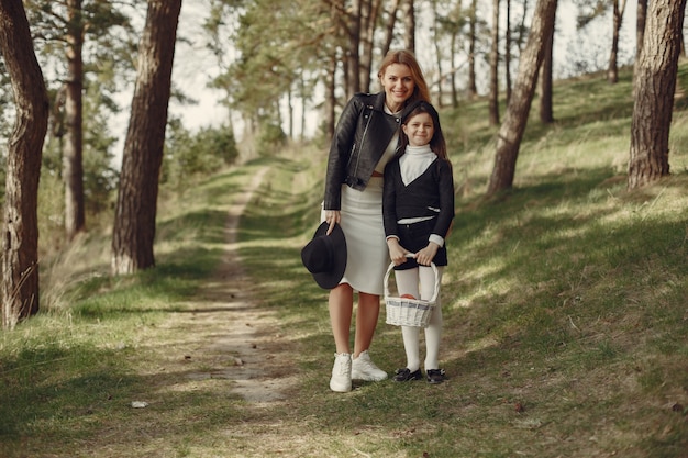 Free photo elegant mother with daughter in a summer forest