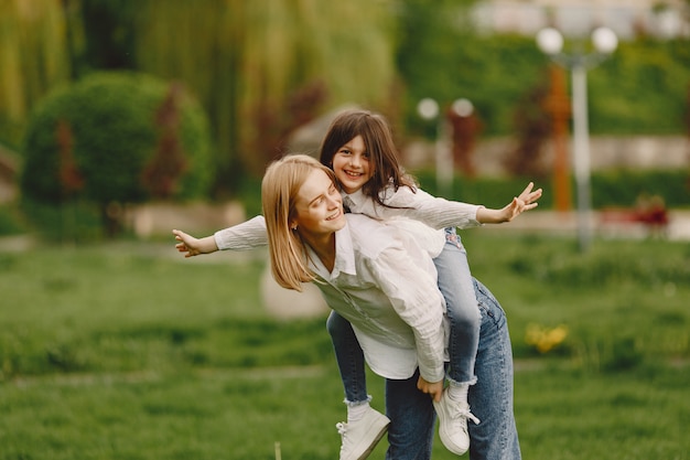 Elegant mother with daughter in a summer forest