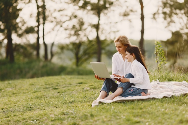 Elegant mother with daughter in a summer forest