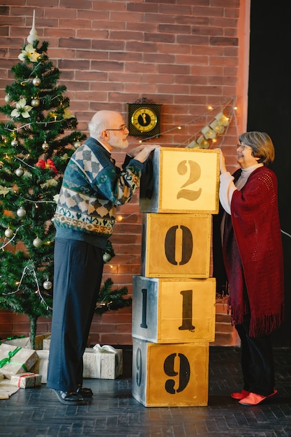 Free photo an elegant old couple are celebrating christmas