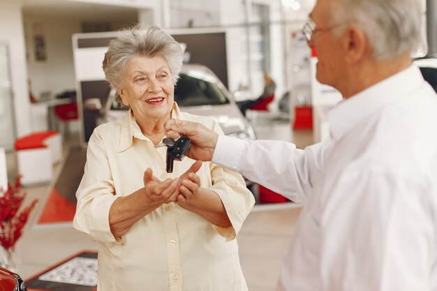 Elegant old couple in a car salon