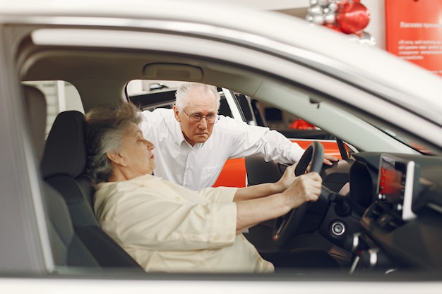 Elegant old couple in a car salon