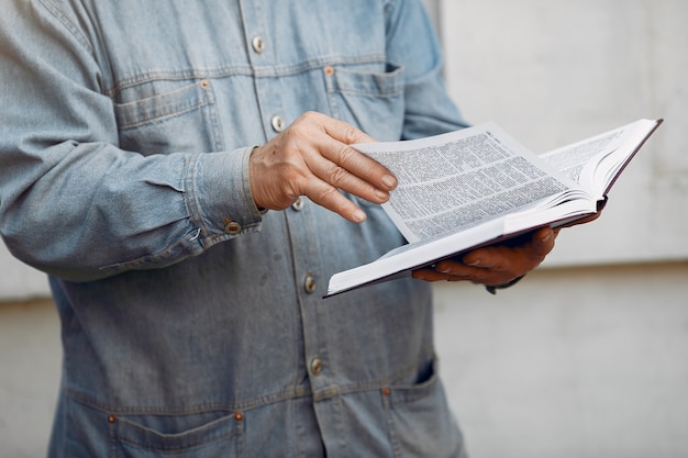 Elegant old man standing with a book