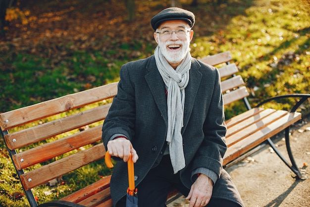 Elegant old man in a sunny autumn park 