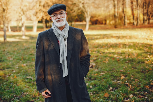 Elegant old man in a sunny autumn park 