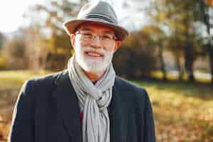 Free photo elegant old man in a sunny autumn park