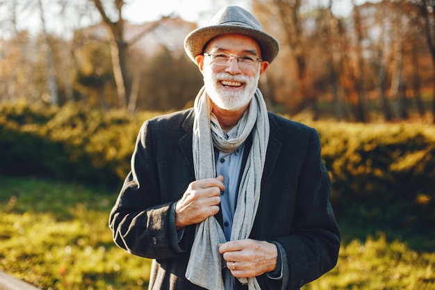 Free Photo elegant old man in a sunny autumn park 