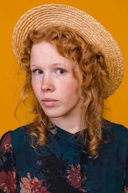 Elegant redheaded female in studio with colored background