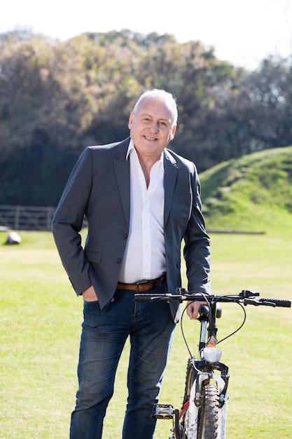 Elegant senior businessman next to his bike