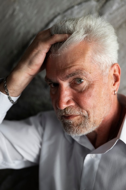 Free photo elegant senior man posing in white shirt