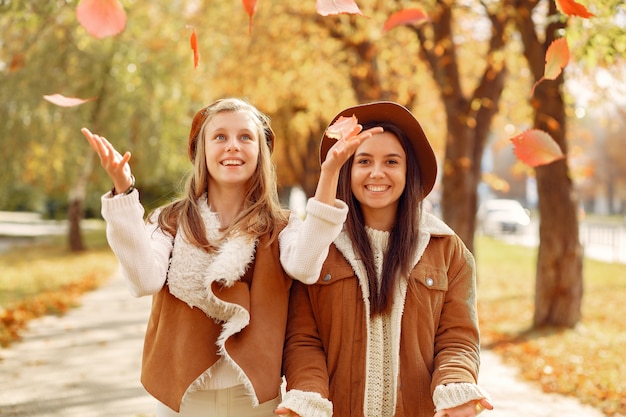 Free photo elegant and stylish girls in a autumn park