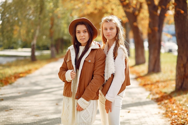 Free photo elegant and stylish girls in a autumn park