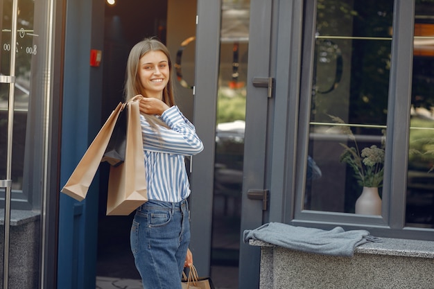 Free photo elegant and stylish girls in the street with shopping bags