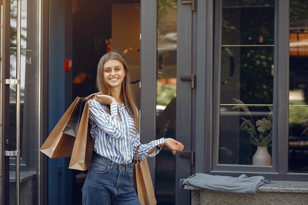 Free photo elegant and stylish girls in the street with shopping bags