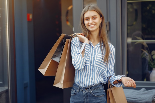 Free photo elegant and stylish girls in the street with shopping bags