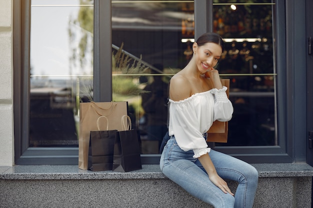 Free photo elegant and stylish girls in the street with shopping bags