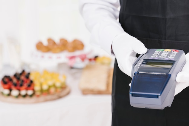 Free photo elegant waiter holding a dataphone