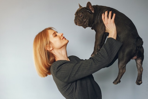 Free photo elegant woman in a black suit with black bulldog