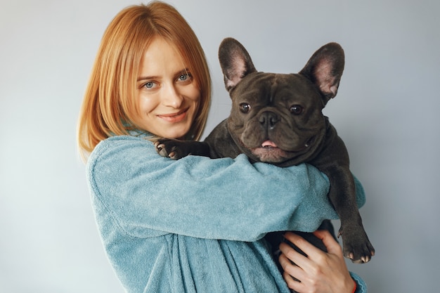 Free Photo elegant woman in a blue bathrobe with black bulldog