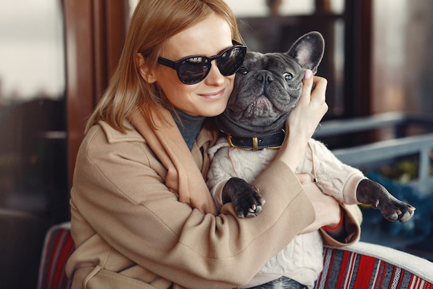 Free Photo elegant woman in a brown coat with black bulldog