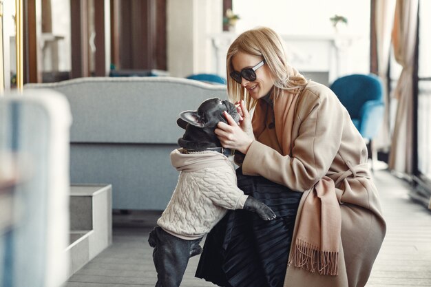 Elegant woman in a brown coat with black bulldog