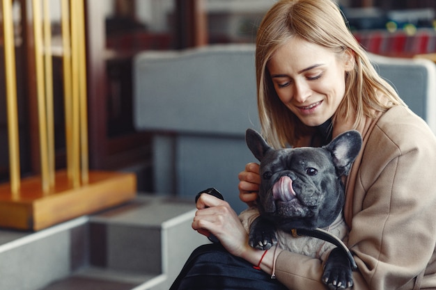 Free photo elegant woman in a brown coat with black bulldog