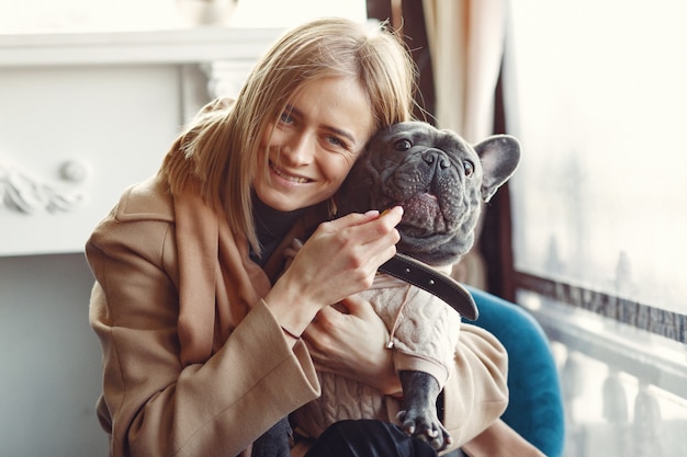 Free Photo elegant woman in a brown coat with black bulldog