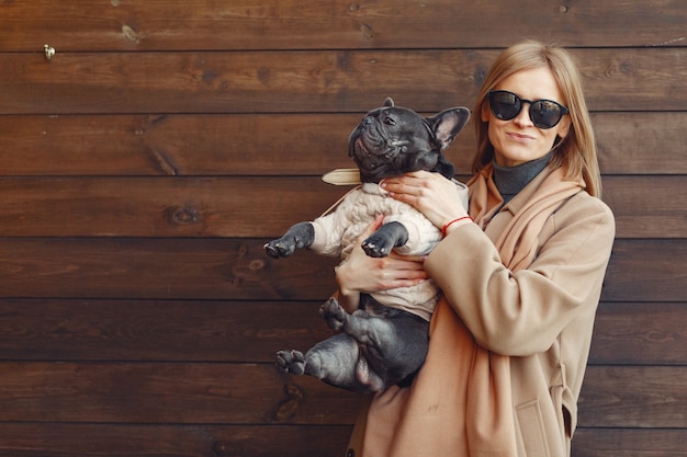 Free Photo elegant woman in a brown coat with black bulldog