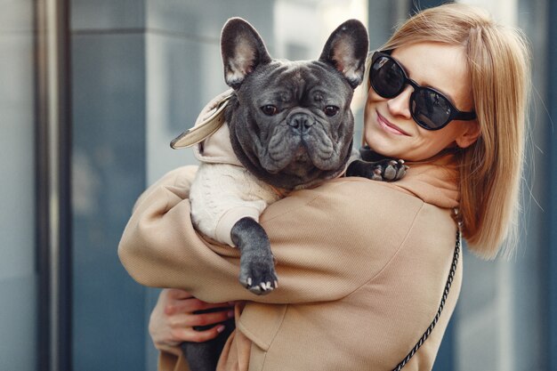 Free photo elegant woman in a brown coat with black bulldog