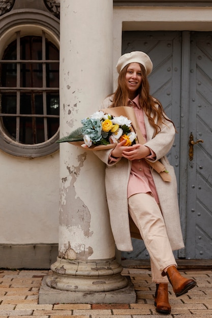 Elegant woman outdoors holding bouquet of flowers in the spring