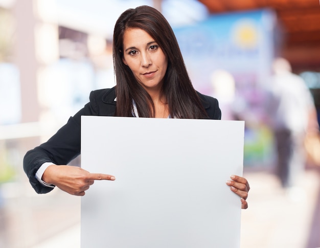 Free Photo elegant woman pointing a blank poster