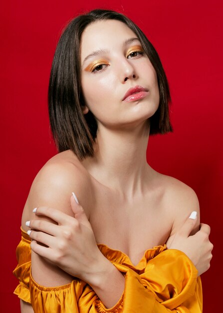 Elegant woman posing in yellow dress and bare shoulders