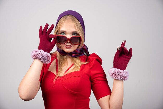 Free photo elegant woman in red dress holding her glasses.