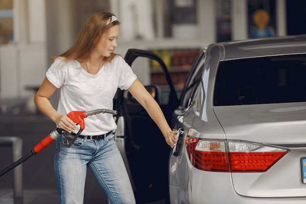 Free photo elegant woman standing on a gas station