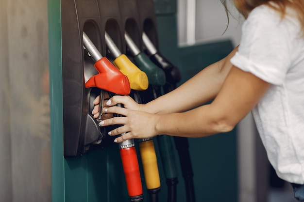 Free photo elegant woman standing on a gas station