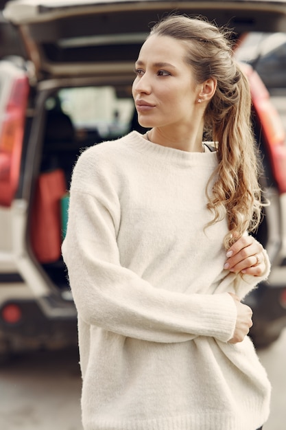 Elegant woman in a white sweater in a spring city