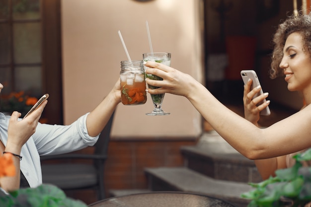 Elegant women drinks cocktails in a summer city