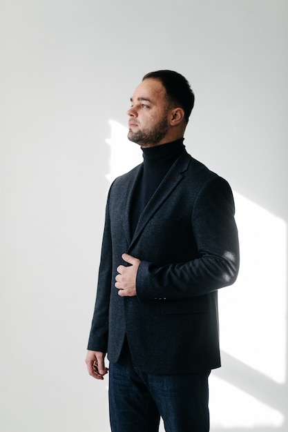 Elegant young handsome man in classic black costume. Studio fashion portrait.