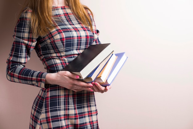 Elegant young woman holding several books