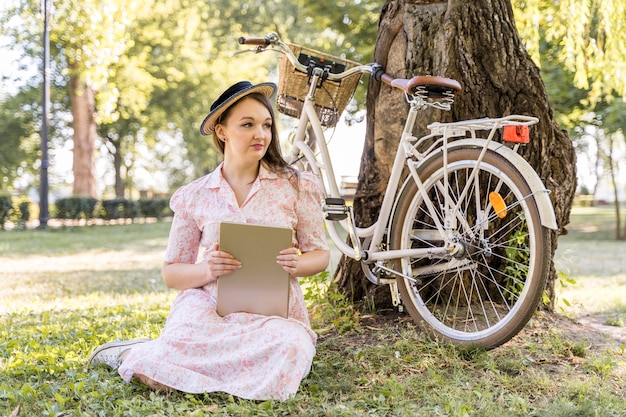 Elegant young woman posing with bike