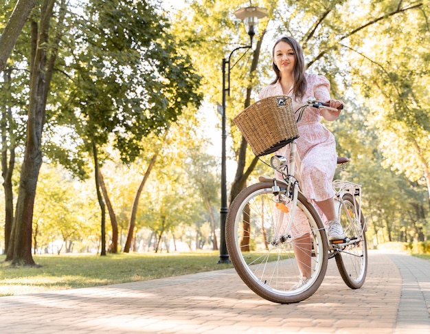 Elegant young woman riding bicycle