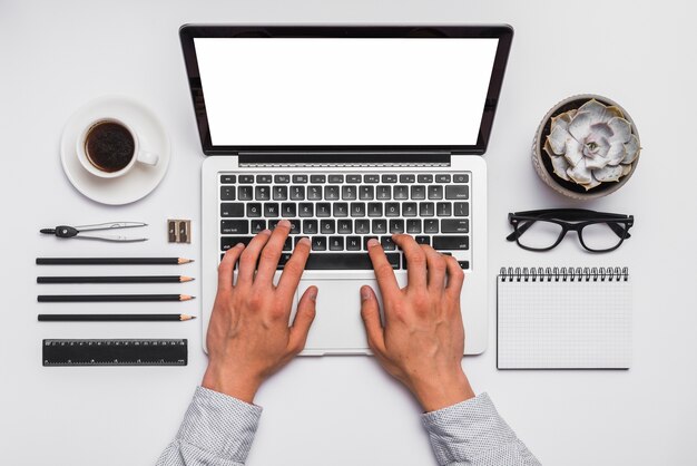 Elevated of a person's hand working on laptop in office