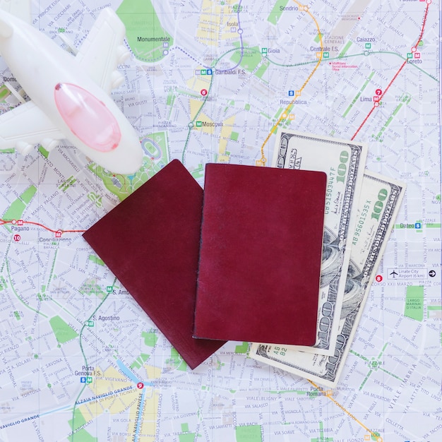 Free photo elevated view of airplane; passport; banknotes and map