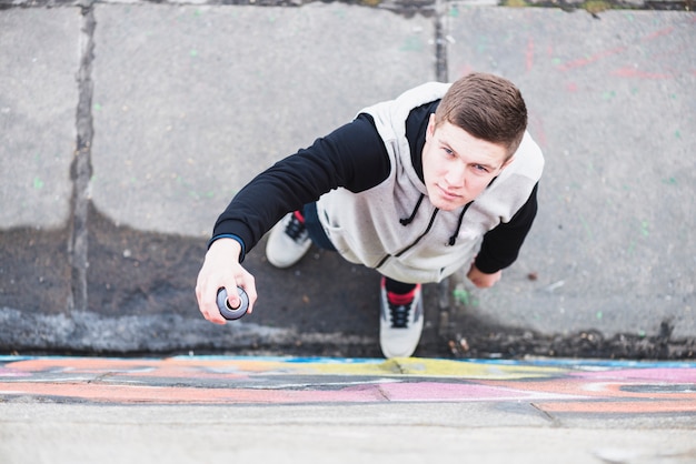 Elevated view of artist holding aerosol can looking up