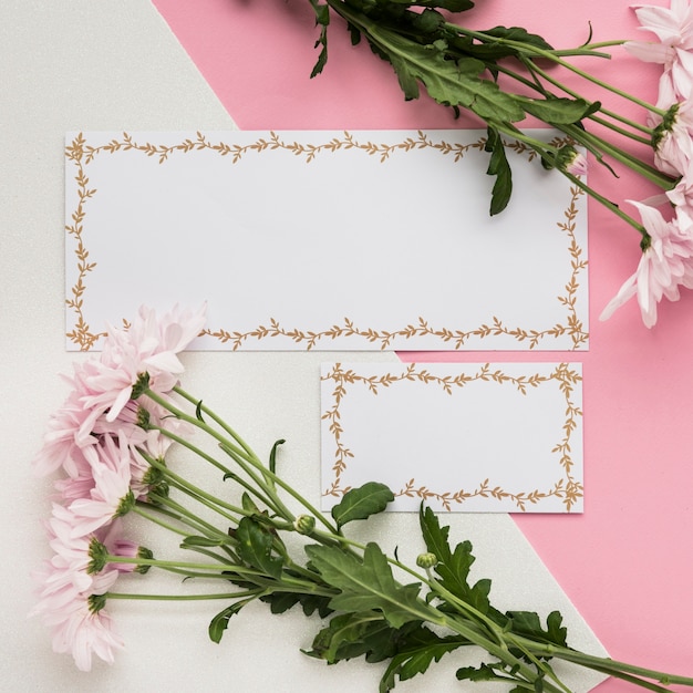 Free photo elevated view of blank card with fresh flowers on dual background