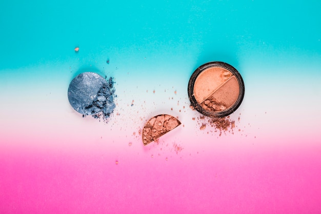 Free photo elevated view of blusher and grey powder ball on colorful background