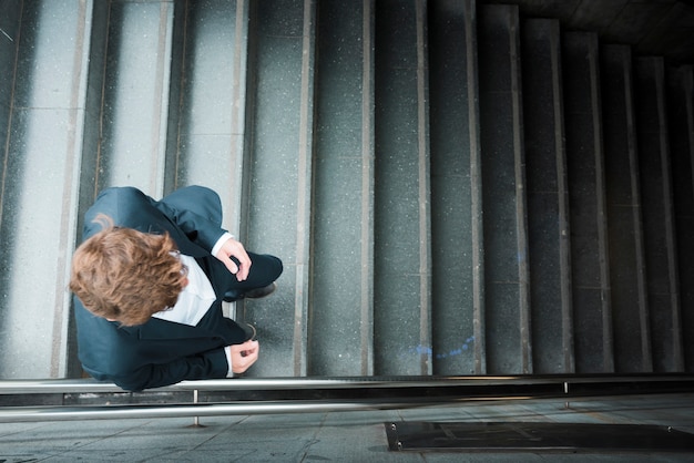 Free photo an elevated view of a businessman walking downstairs