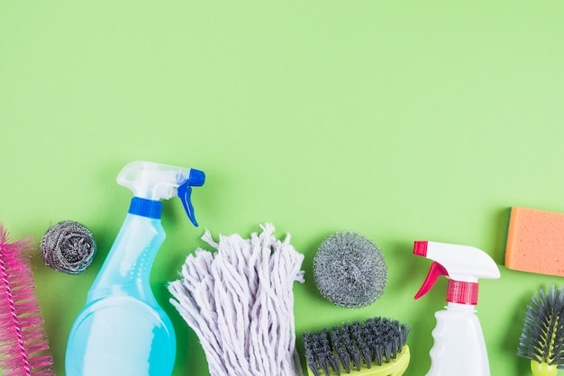 Elevated view of cleaning supplies on green backdrop