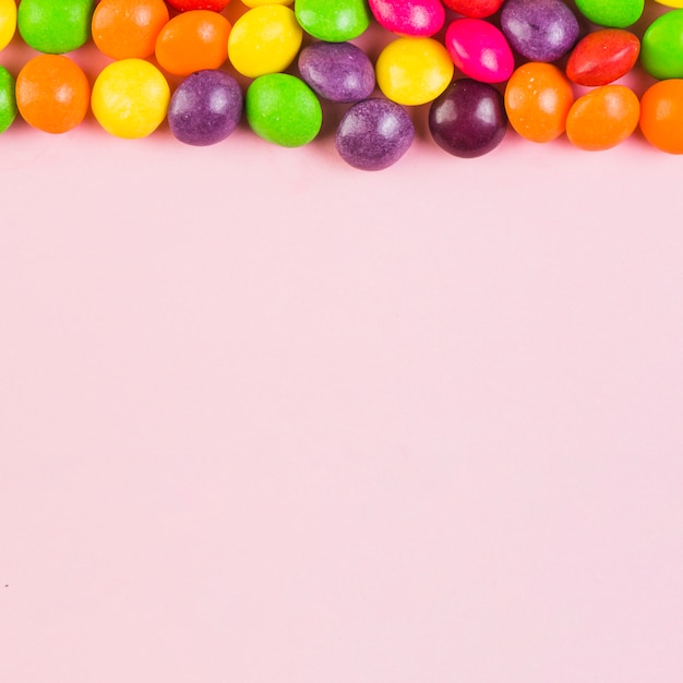 Free photo elevated view of colorful candies at the top of pink background